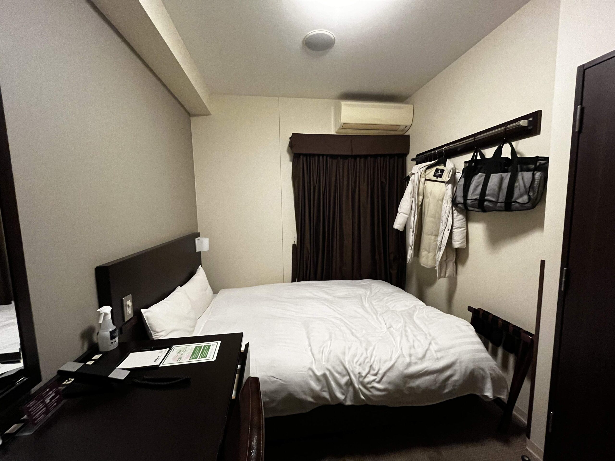 床尾雖然幾乎緊鄰牆壁，但還是有一點空間可以掛大衣