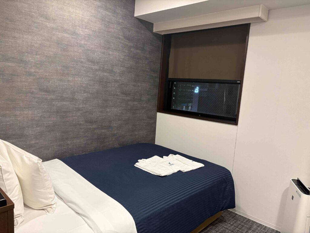 日本福島縣郡山市住宿推薦:Hotel LiveMax福島郡山站前,2人房CP值超高,用品包括微波爐一應俱全|日本福島自駕遊 7 Hotel LiveMax的雙人床對著一個小窗戶,早上陽光灑落很舒服